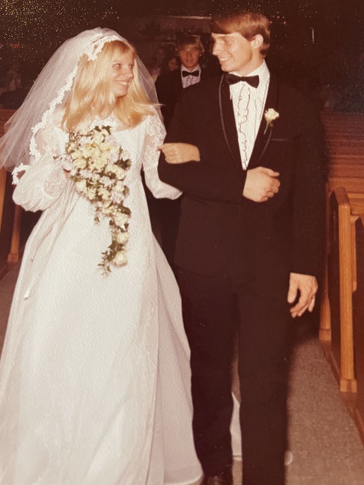 a bride and groom walking down the aisle