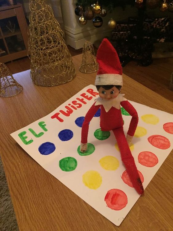 an elf is sitting on top of a sheet of paper that says, elf twister