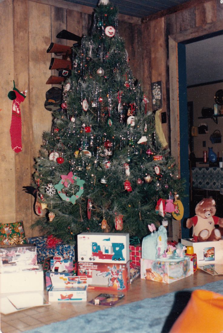 a christmas tree is decorated with ornaments and gifts for the family to put on it