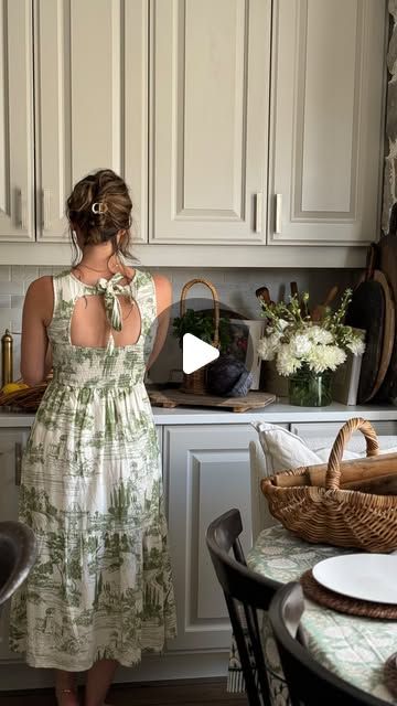 a woman standing in a kitchen next to a table