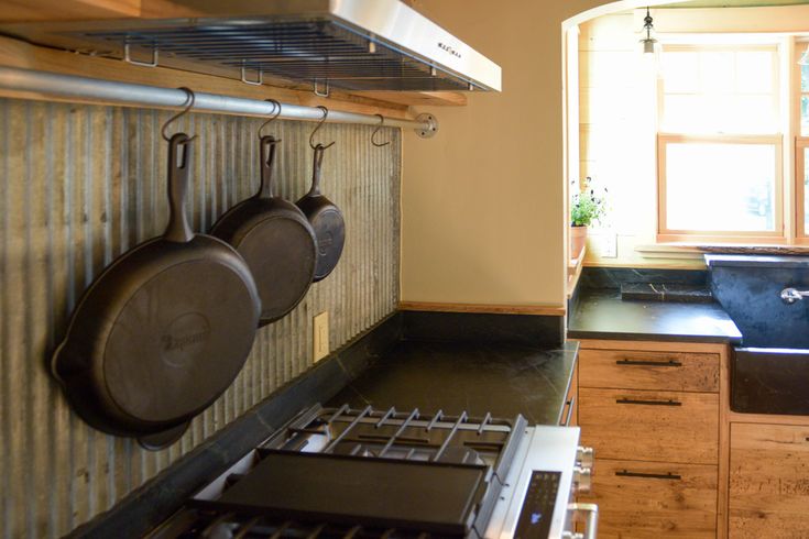 pots and pans hanging on the wall in a kitchen