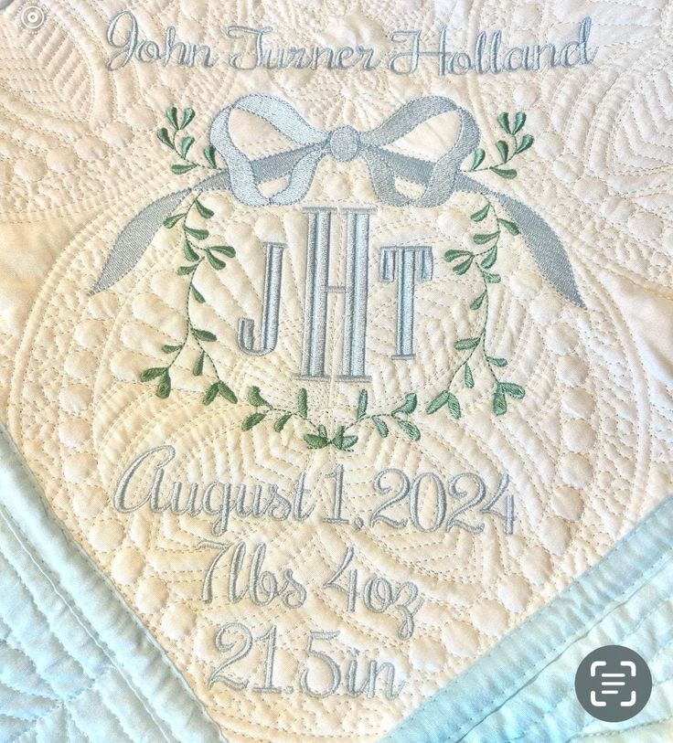 a quilted birth blanket with a monogrammed name and date on the front