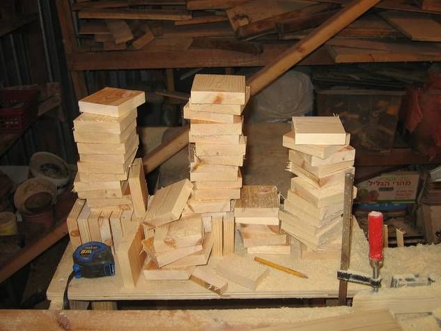 several pieces of wood stacked on top of each other in front of a workbench