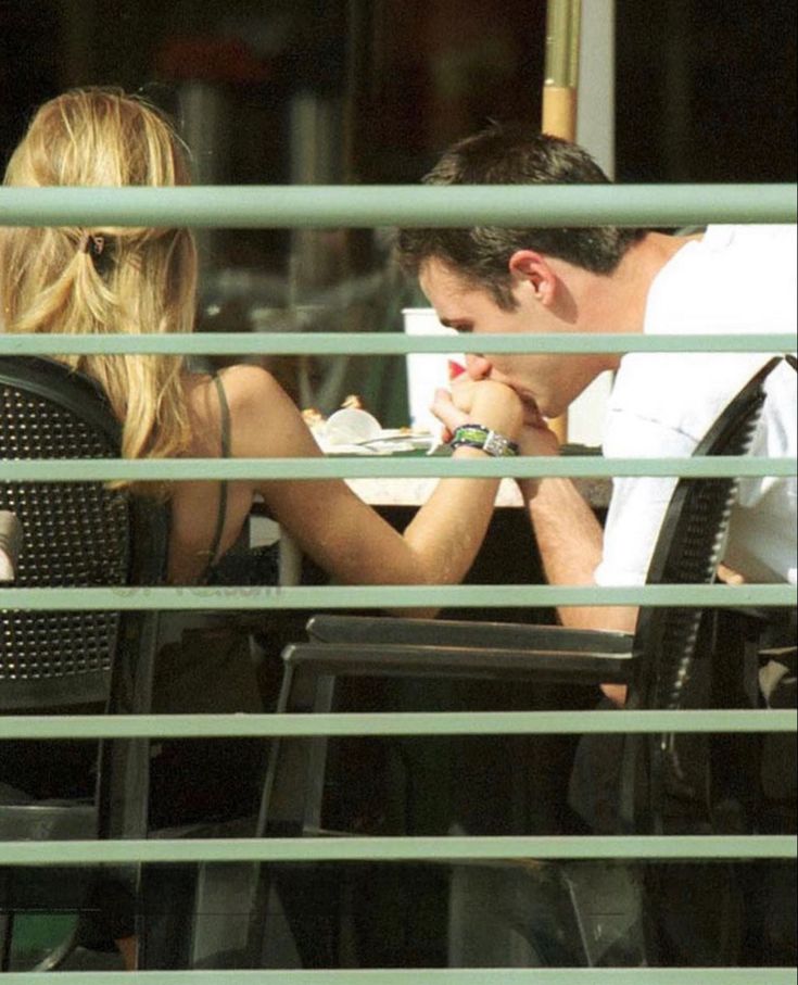 a man and woman sitting at an outdoor table