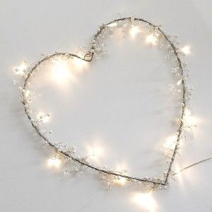 a heart - shaped string of lights is shown on a white surface with small stars