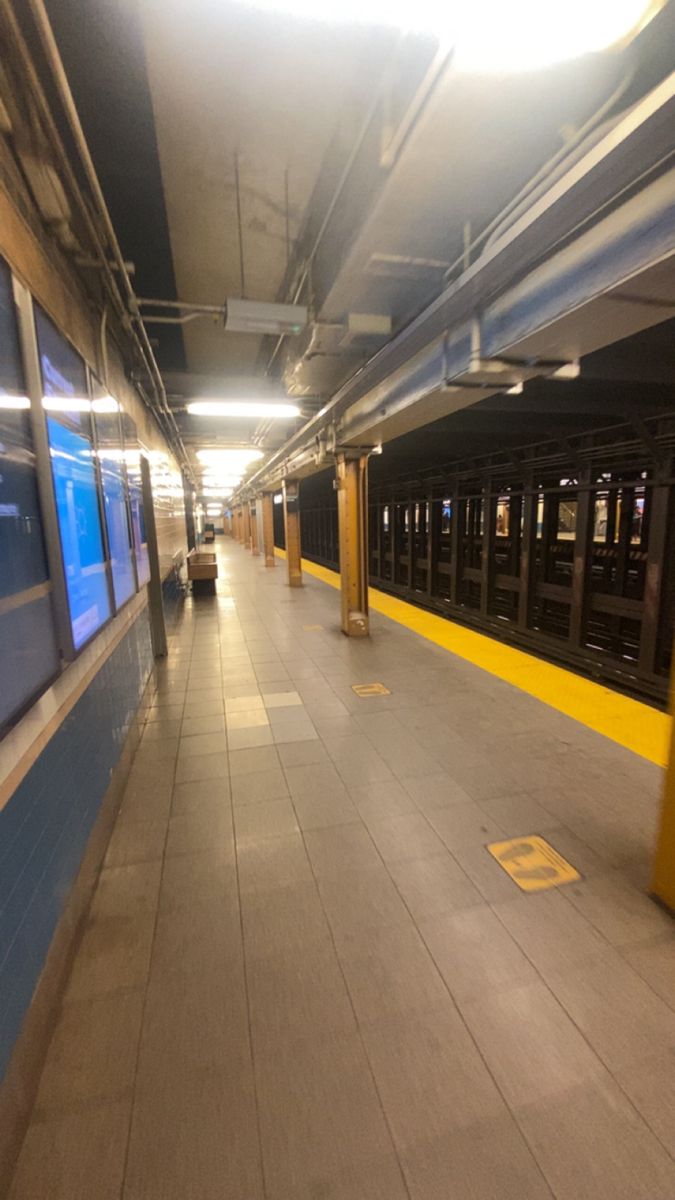 an empty subway station with no people on the platform or in the distance, there is only one train