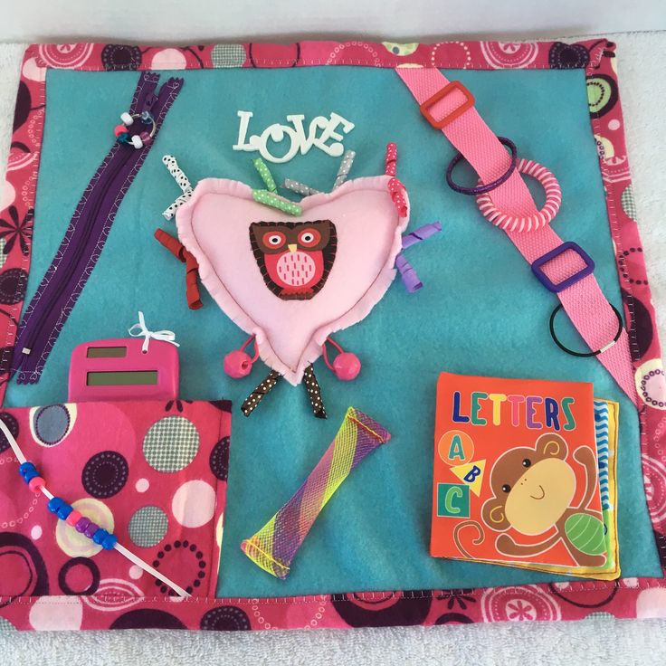 an assortment of items on a pink and blue cloth with the word love written in it