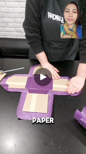 a woman is making a paper cross out of cardboard