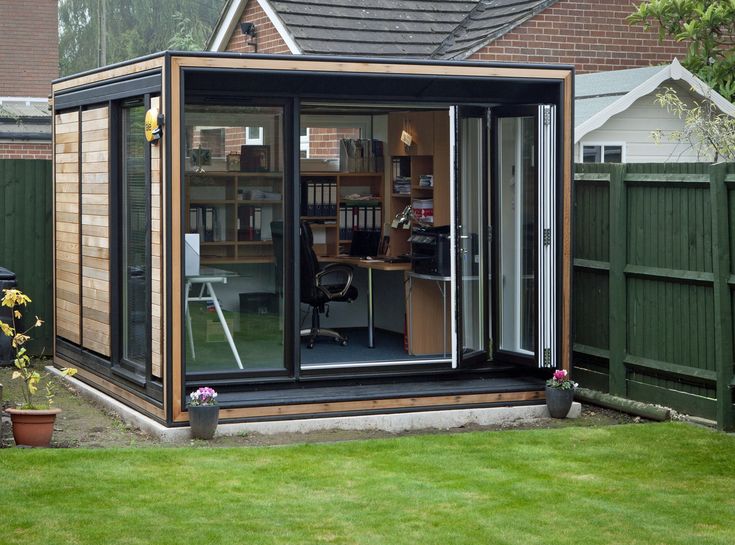 a small backyard office with sliding glass doors