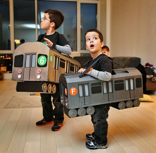 two young boys are dressed up as trains