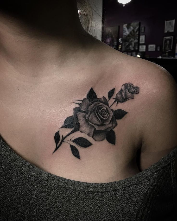 a woman's chest with a rose tattoo on it