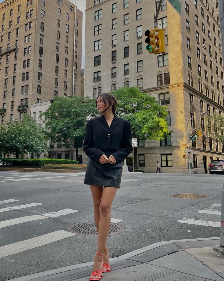 a woman standing in the middle of an intersection