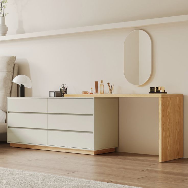 a living room with a white couch and a wooden dresser in front of a mirror