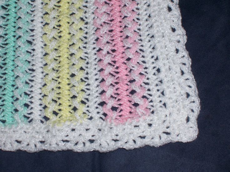 a crocheted dishcloth with multicolored yarns on the bottom and sides