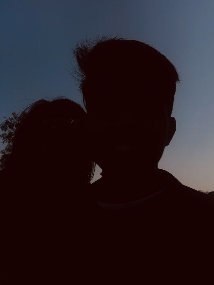 a man and woman are silhouetted against the sky