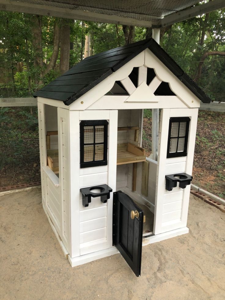 a white and black doll house with its door open