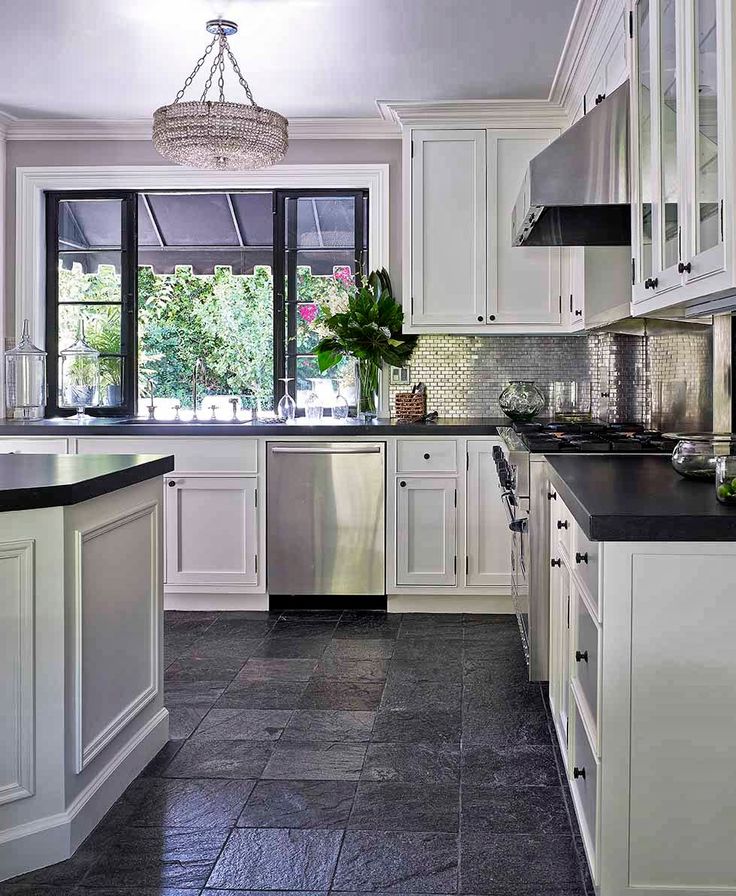 a kitchen with white cabinets and black counter tops