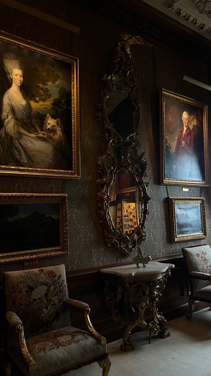 an ornately decorated room with paintings on the wall and two chairs in front of them