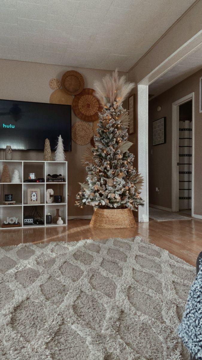 a living room with a christmas tree in the corner and other decorations on the wall