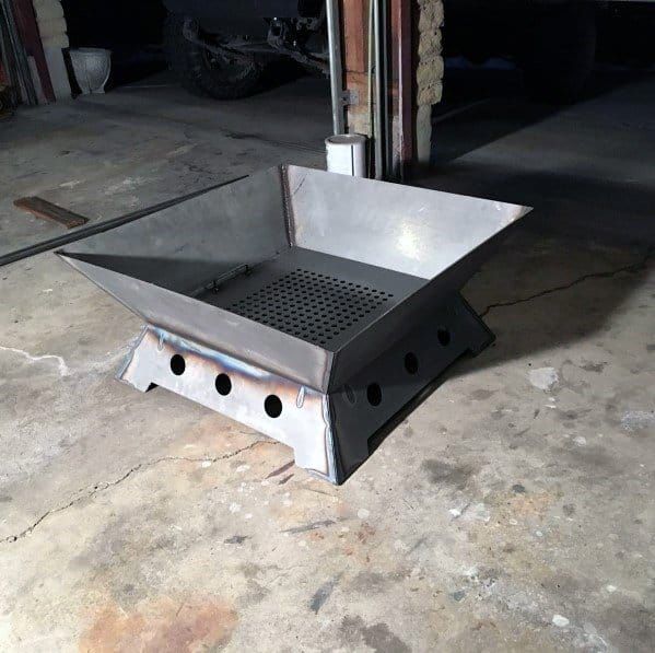 a square metal object sitting on top of a cement floor next to a garage door