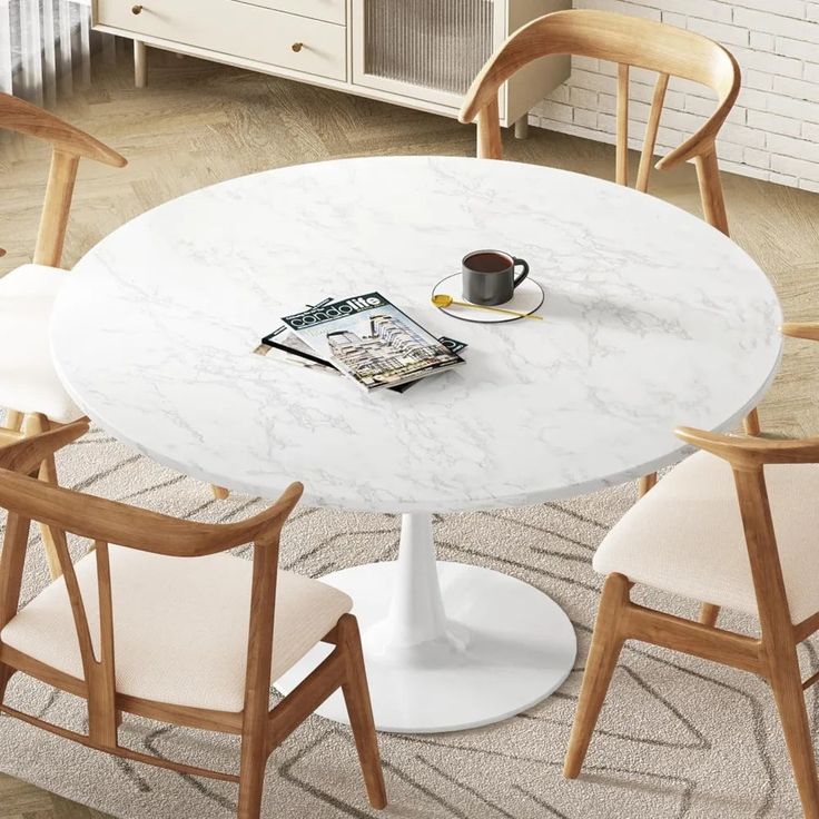 a white table with chairs around it and a magazine on the table next to it