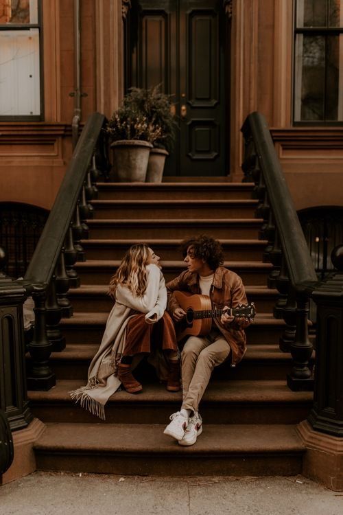 two people sitting on the steps talking to each other