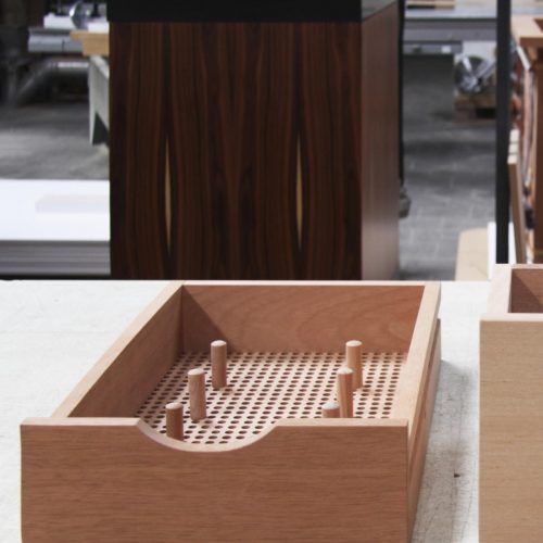 two wooden boxes sitting on top of a white table next to each other with holes in them