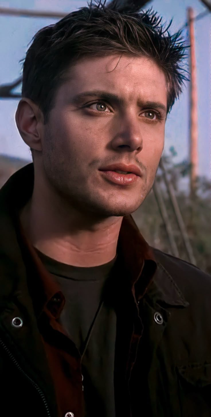 a close up of a person wearing a jacket and looking at the camera with an intense look on his face