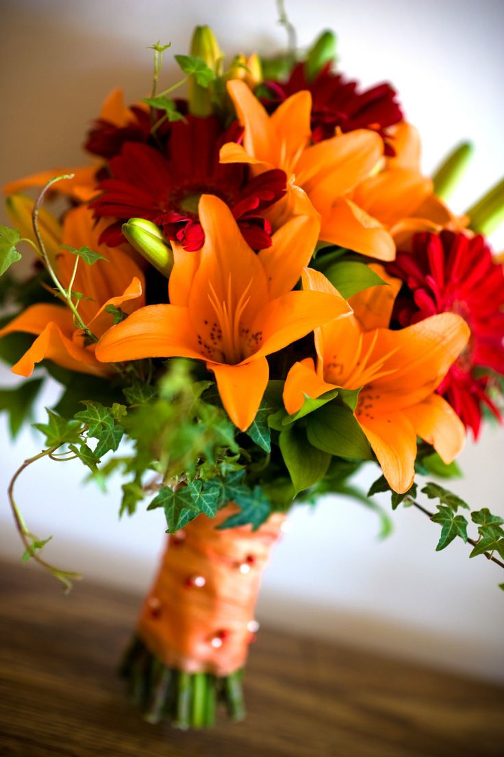 a bouquet of orange and red flowers on a table