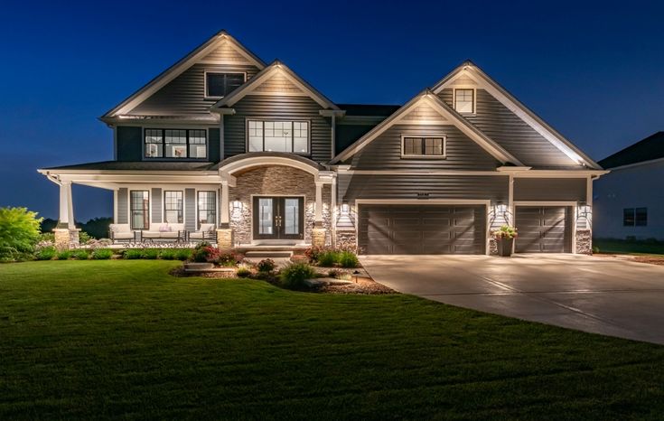 a large house lit up at night with lights on the front and side of it