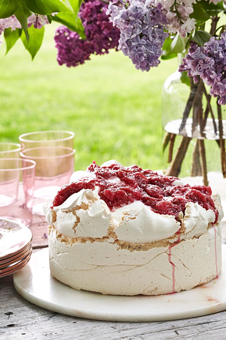 a cake sitting on top of a table covered in frosting and raspberries