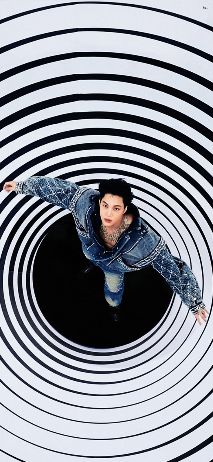 a man is standing in the middle of a black and white spiral