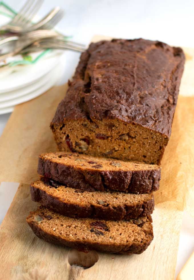 a loaf of chocolate chip banana bread on a cutting board with two slices cut off