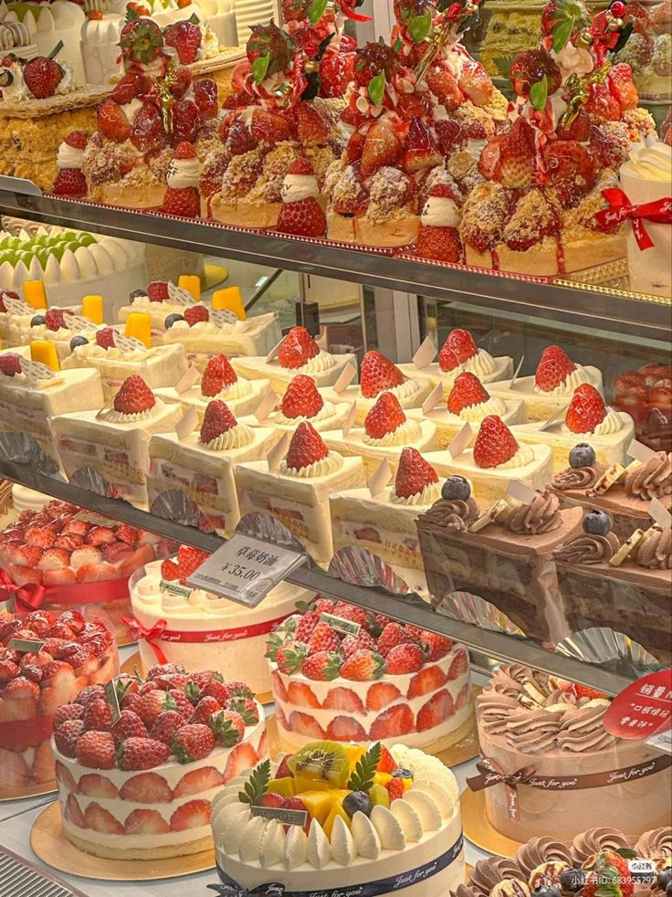 a display case filled with lots of different types of cakes and desserts on top of shelves