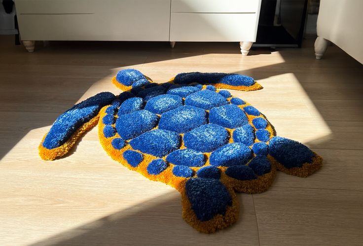 a blue and yellow turtle rug sitting on the floor