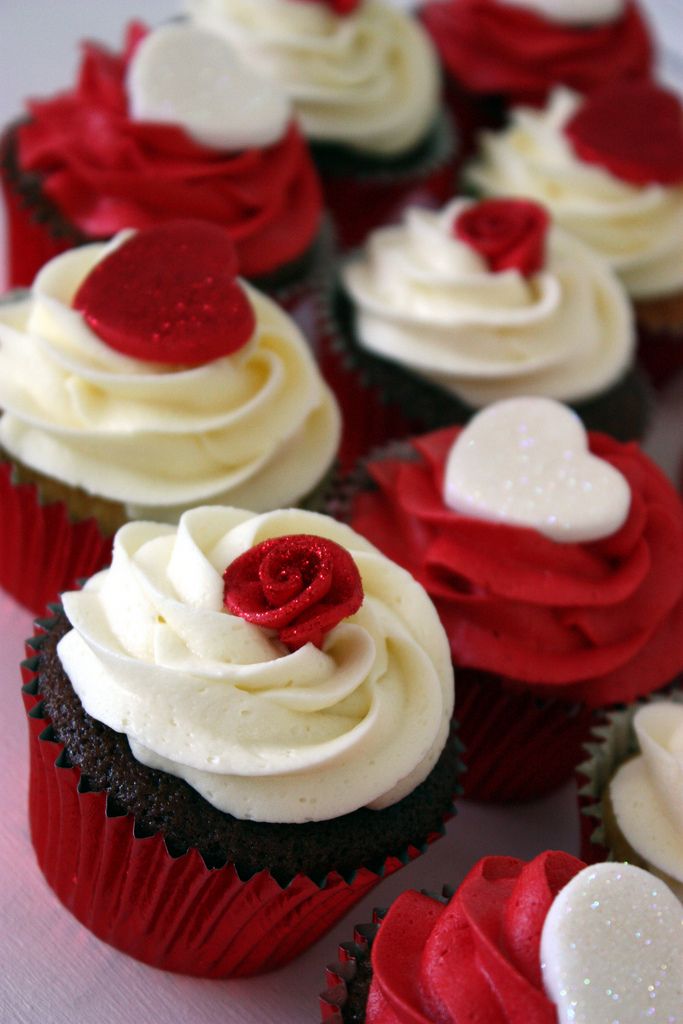 cupcakes with white frosting and red decorations