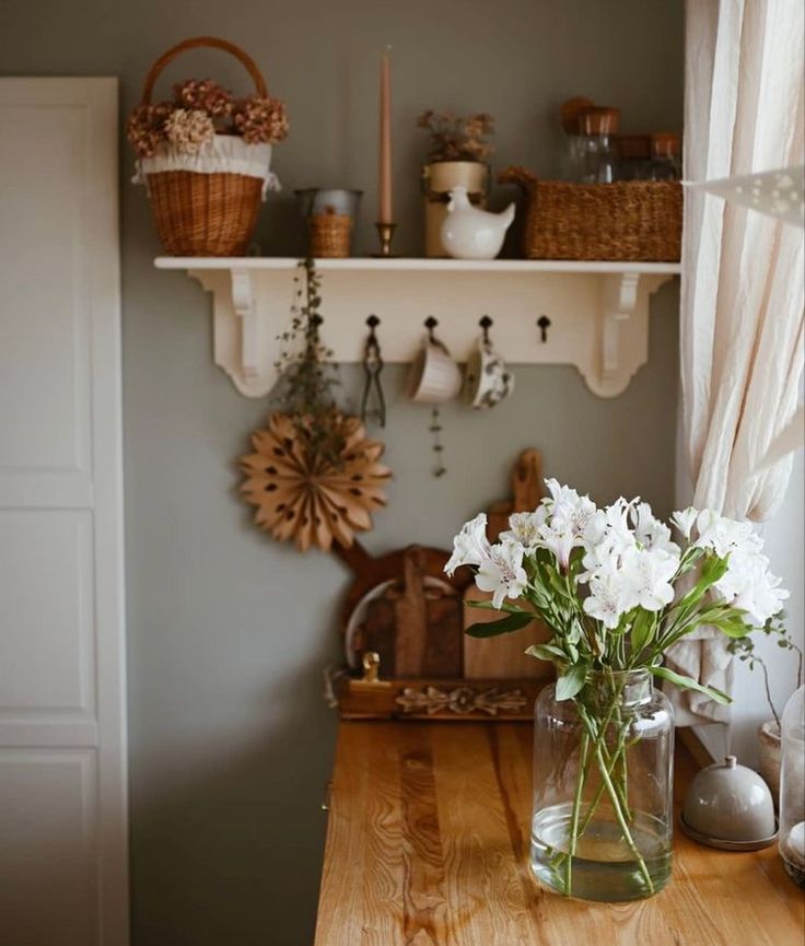 a vase filled with white flowers sitting on top of a wooden table