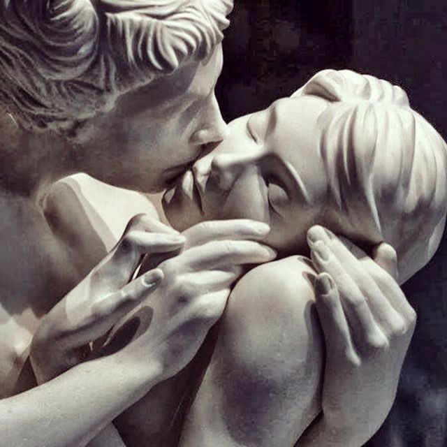 a statue of two people kissing each other with their hands on the face and shoulders