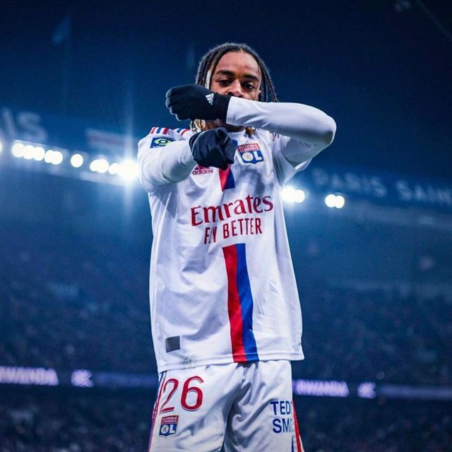 a man standing on top of a soccer field holding his hand up to his face