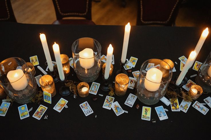 there are many candles and cards on the table