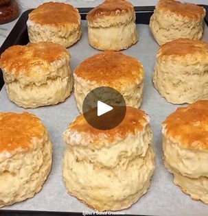 a pan filled with lots of biscuits on top of a counter next to doughnuts