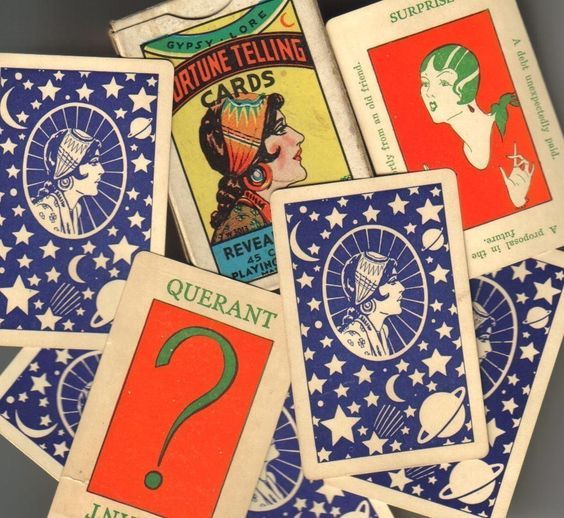 several vintage playing cards are stacked on top of each other, with one question mark in the middle