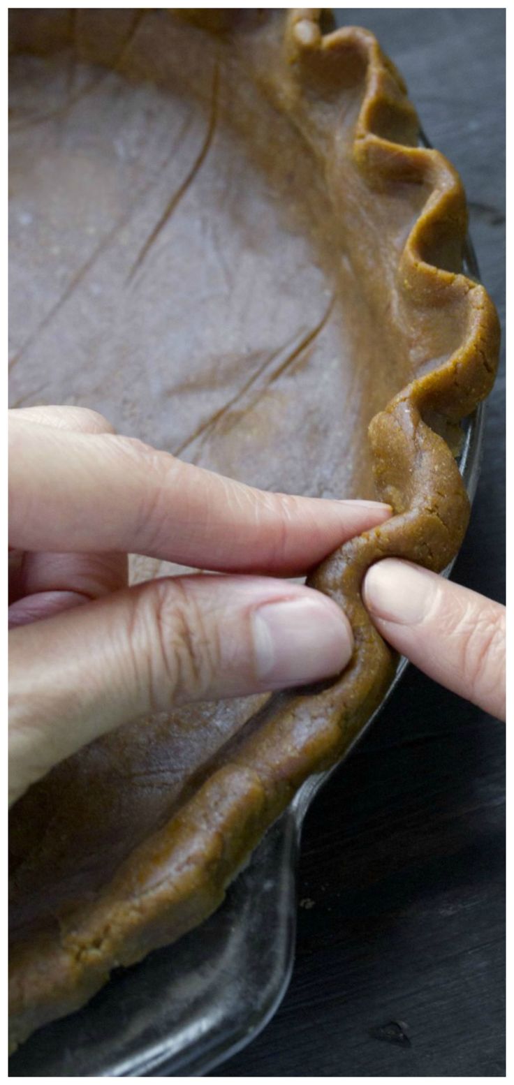 a person placing peanut butter on top of a pie crust