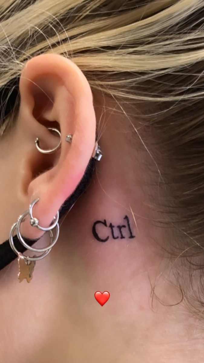 a woman with a small tattoo behind her ear