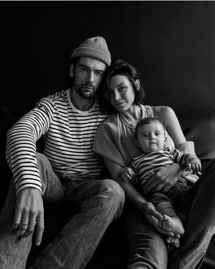 a man and woman are sitting on a couch with a baby