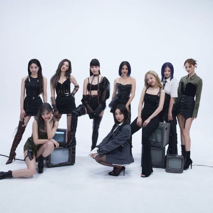 a group of women posing for a photo in front of a white background with an old tv