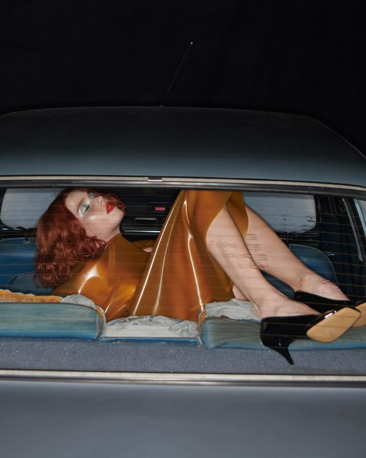 a woman laying in the back of a car with her legs up and wearing high heels