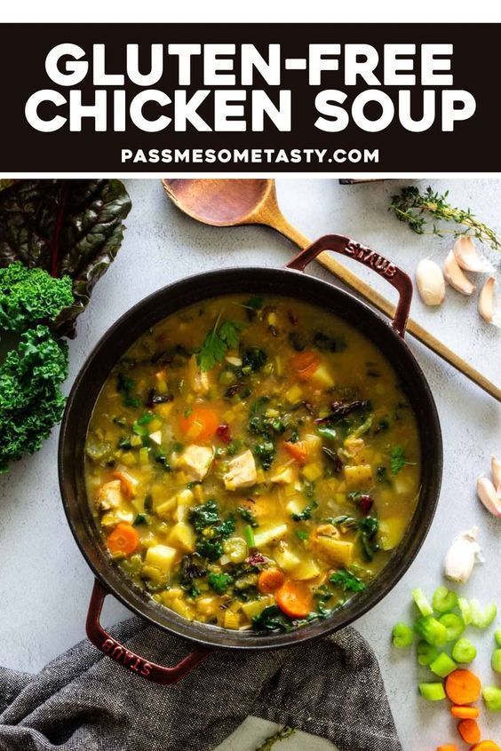 a pan filled with chicken soup next to vegetables