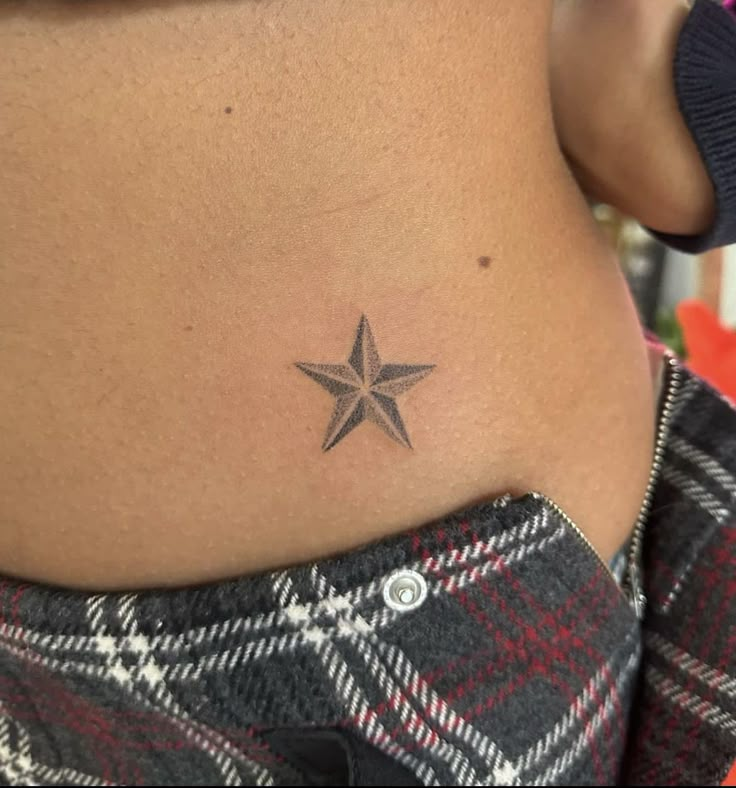 a woman with a small star tattoo on her stomach