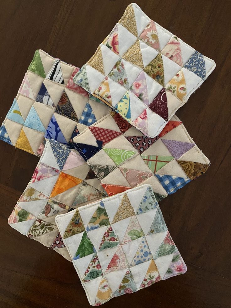 four small quilts are stacked on top of each other in the shape of triangles